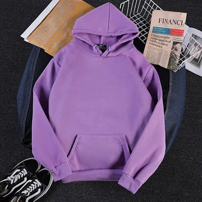 Purple hoodie on a dark surface with books and a newspaper underneath