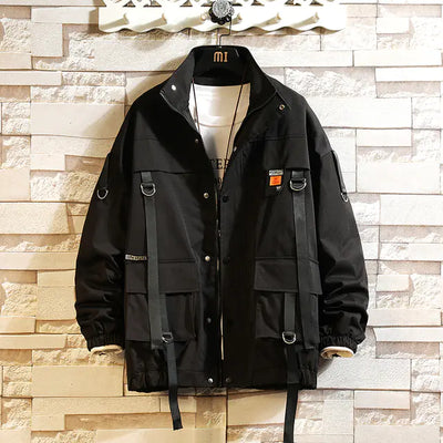 Black jacket with multiple pockets and straps on a textured wall background