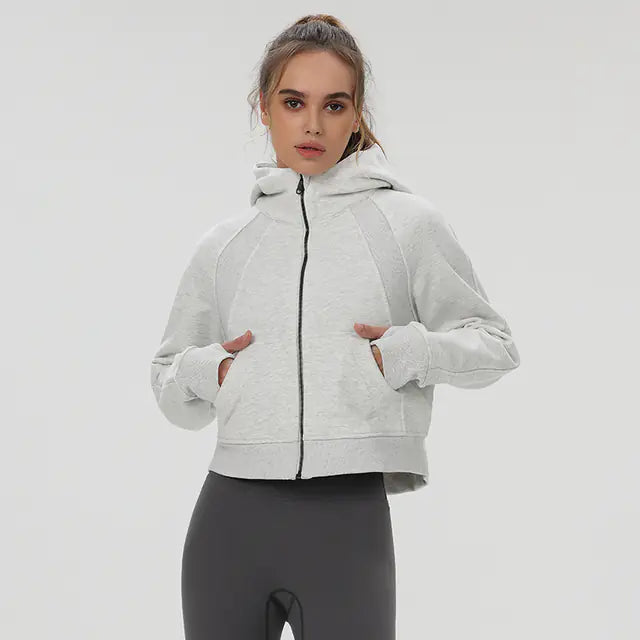 Woman wearing a light gray hoodie with a zipper on a white background
