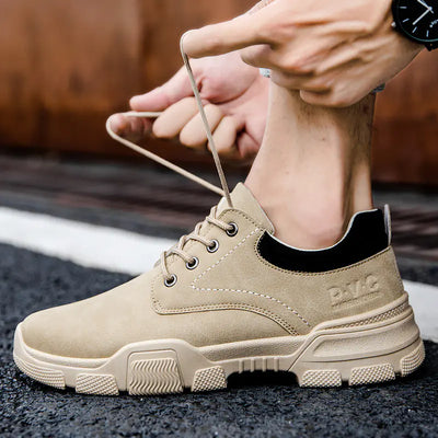 Beige work boots being worn on a blurred background