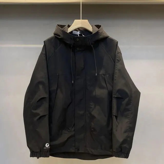 Black jacket on a hanger against a neutral background