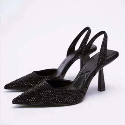 Black high-heeled shoes with rhinestone embellishments on a white background