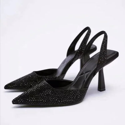 Black high-heeled shoes with rhinestone embellishments on a white background