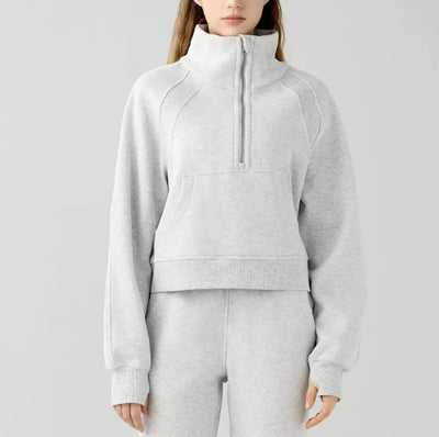 Person wearing a gray tracksuit on a light gray background