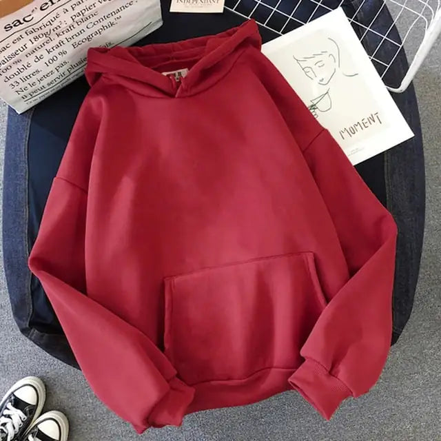 Red hoodie on a surface with books and shoes in the background