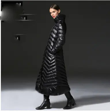 Woman wearing a long black puffer coat against a dark background