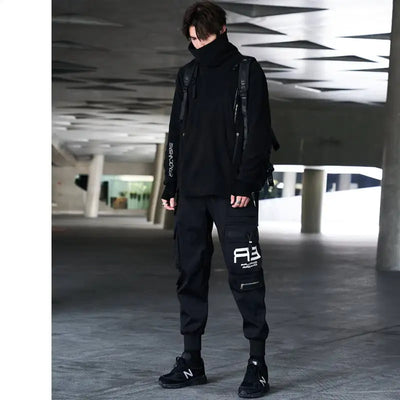 Person wearing a black outfit with visible branding in an urban setting
