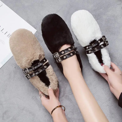 Three pairs of fluffy slippers with studded details on a gray surface.