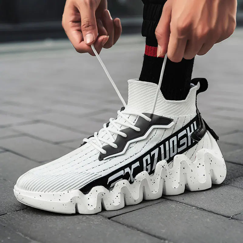 White sock sneaker with black accents being tied on a pavement background