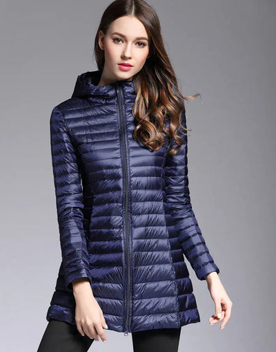 Woman wearing a blue puffer jacket on a gray background