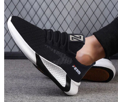 Black and white sneakers with visible branding on a textured surface