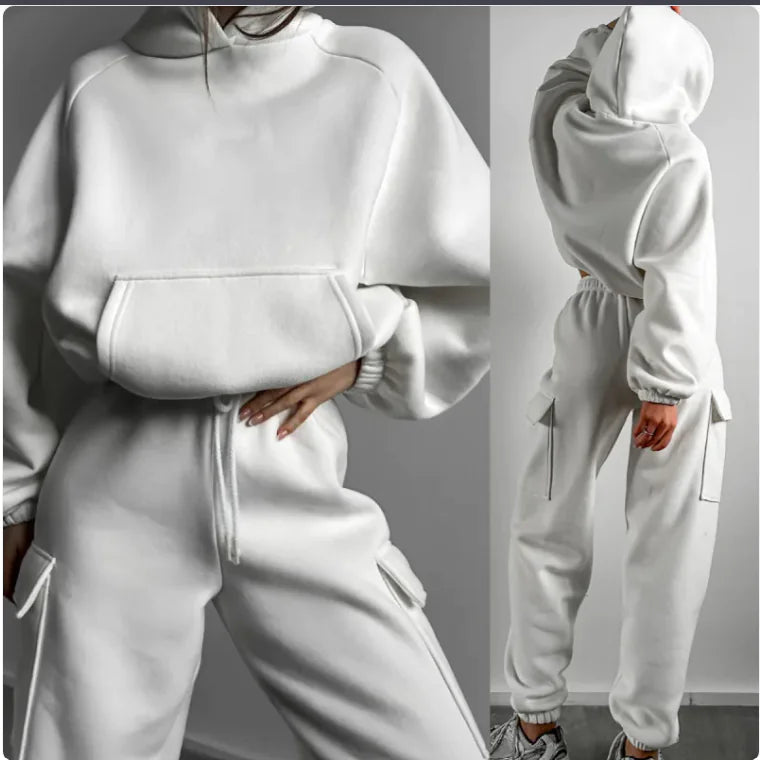 White tracksuit worn by a person on a gray background