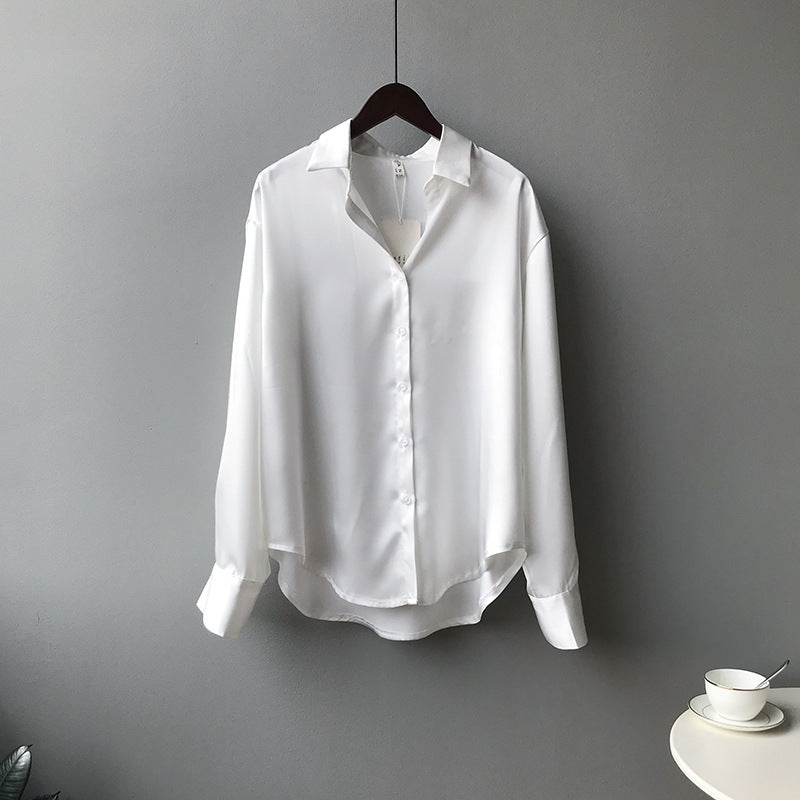 White shirt on a hanger against a gray background