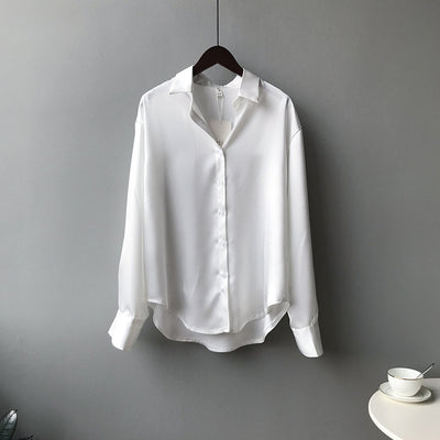 White shirt on a hanger against a gray background