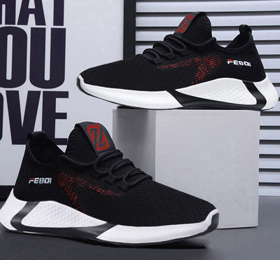 Black and white sneakers with red accents on a gray surface and white background