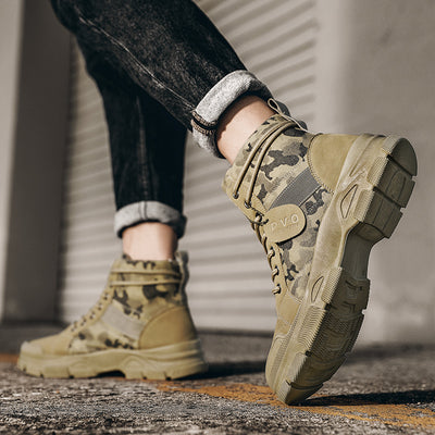 Camouflage boots being worn on a concrete surface with a blurred background
