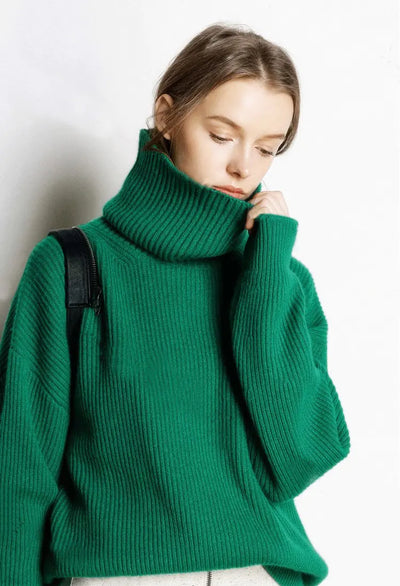 Person wearing a green turtleneck sweater against a white background