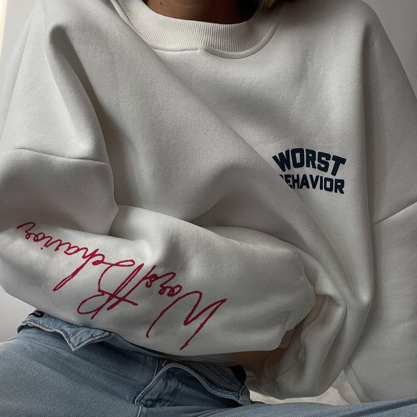 Gray sweatshirt with blue and red text on a plain background