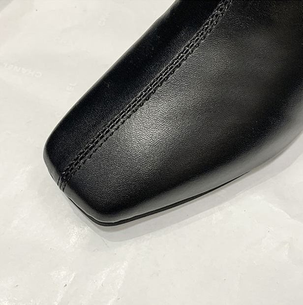 Close-up of a black leather shoe on a light gray background