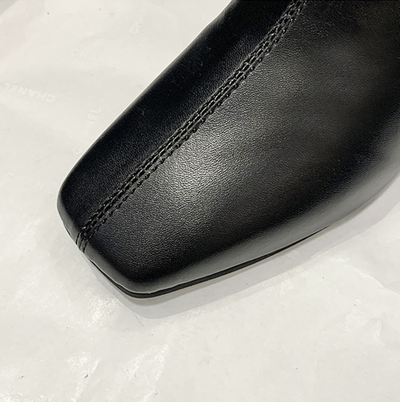 Close-up of a black leather shoe on a light gray background