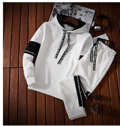 White hoodie and pants with black accents on a wooden floor