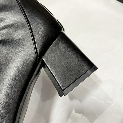 Close-up of a black leather boot with a block heel on a white background