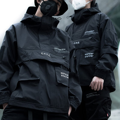 Two people wearing black jackets with text and logos on a neutral background