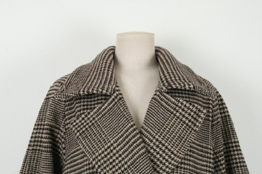 Houndstooth patterned coat on a mannequin against a white background