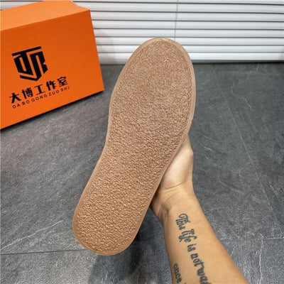 Close-up of a shoe sole with an orange box featuring black text in the background.