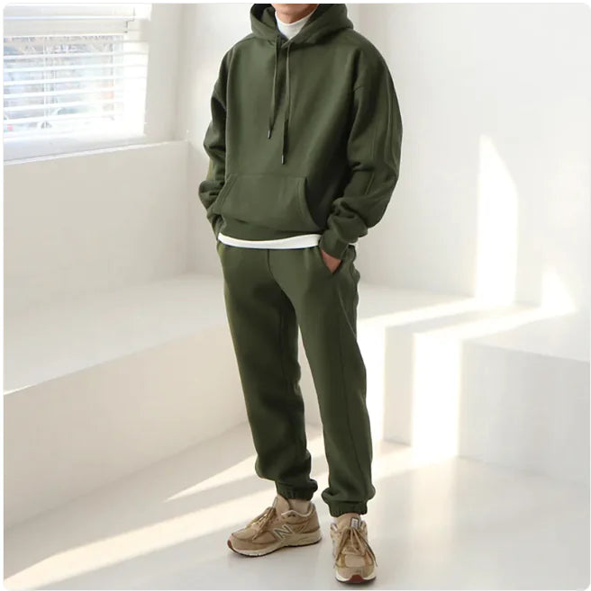 Person wearing a green tracksuit in a bright room with sunlight filtering through blinds.