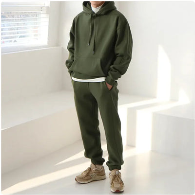 Person wearing a green tracksuit in a bright room with sunlight filtering through blinds.