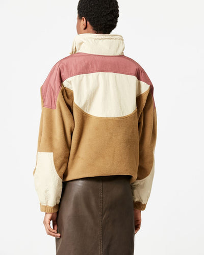Person wearing a color-blocked jacket with pink, beige, and brown sections on a white background.