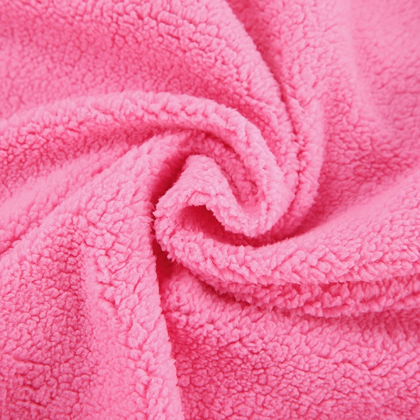 Close-up of a pink fleece blanket with a soft texture.