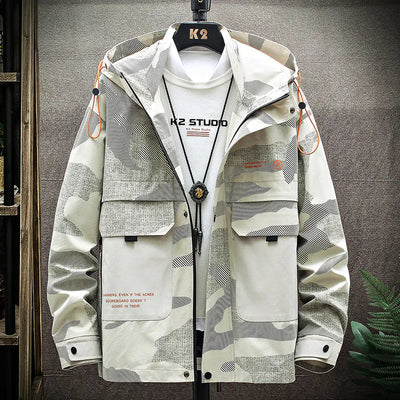 Camouflage jacket with 'K2 Studio' branding on a hanger against a gray background.