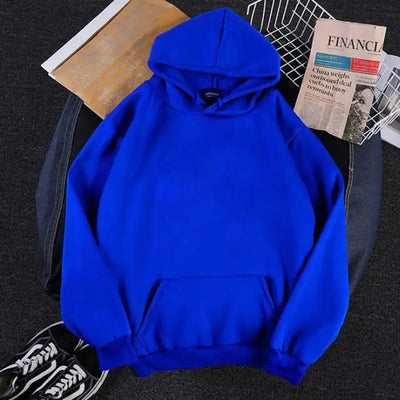 Blue hoodie on a dark surface with a newspaper and shoes in the background