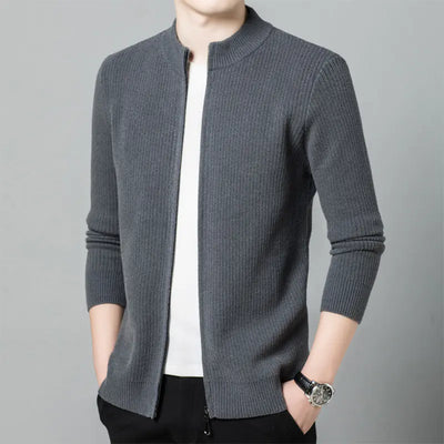 Gray knitted cardigan worn by a person on a gray background