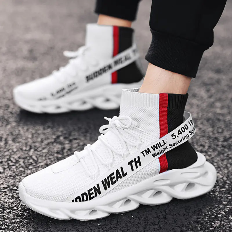 White sneakers with black and red text on a pavement background