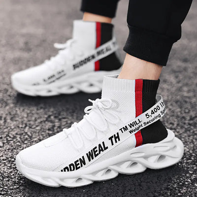 White sneakers with black and red text on a pavement background