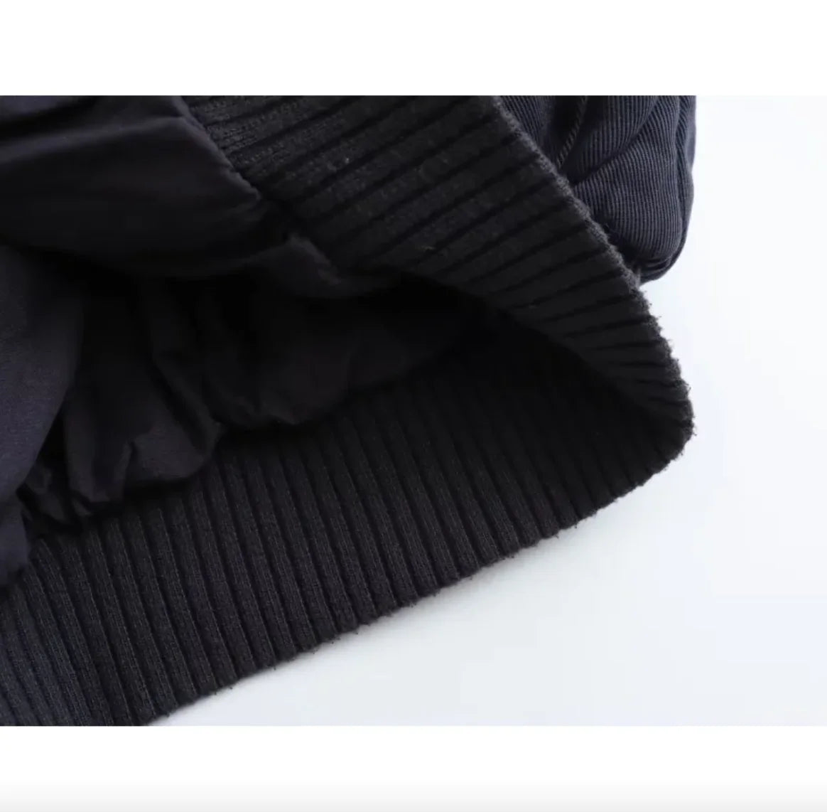 Close-up of a dark blue knitted sweater on a white background
