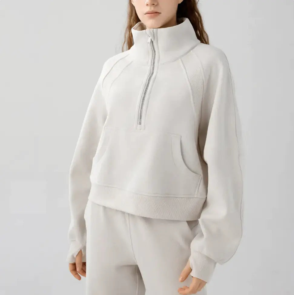 Person wearing a light gray tracksuit on a white background