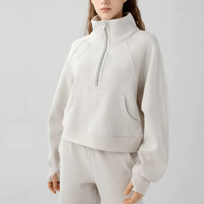 Person wearing a light gray tracksuit on a white background
