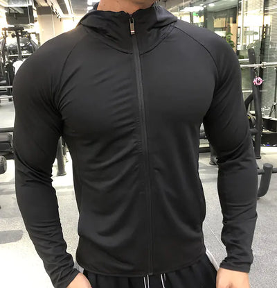 Person wearing a black zip-up hoodie in a gym setting