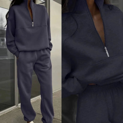 Navy tracksuit worn by a person, with a close-up of the front zipper.