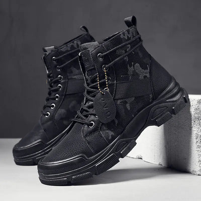 Black tactical boots with camouflage patterns on a gray background