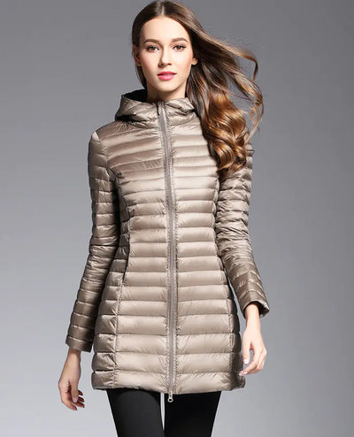 Woman wearing a beige puffer jacket on a gray background