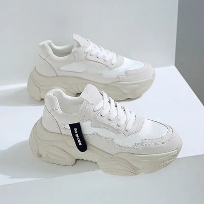 White sneakers with a brand tag on a light gray background