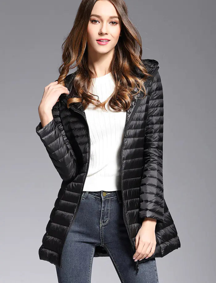 Woman wearing a black puffer coat on a gray background