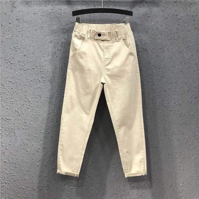 Beige pants hanging on a gray textured wall