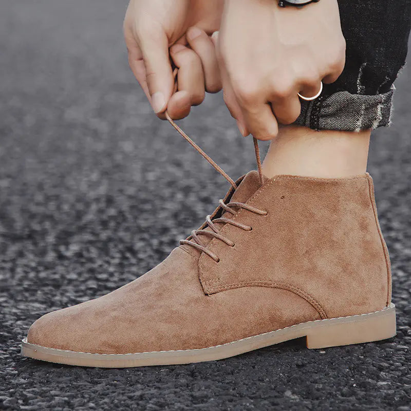 Brown suede boot being worn with a blurred background