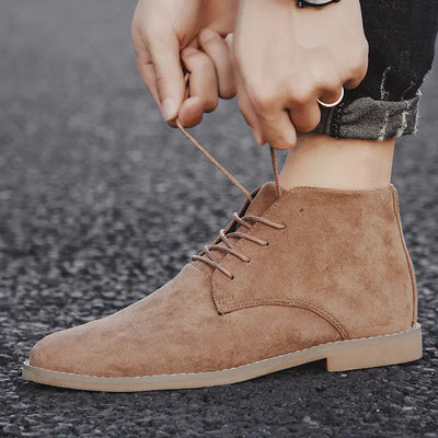 Brown suede boot being worn with a blurred background